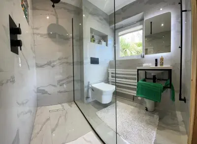 a bathroom with a shower and a toilet and a sink at Brig-y-Don in Aberdyfi