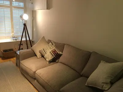 a living room with a couch and a lamp at Riverside Suites Llangollen in Llangollen