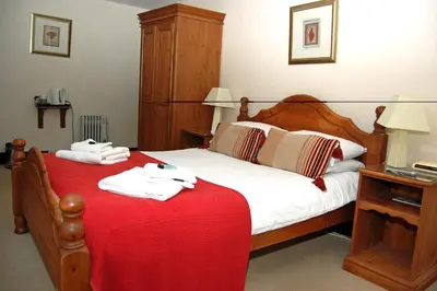 a bedroom with a bed with a red blanket at Old Post Office in Shrewsbury