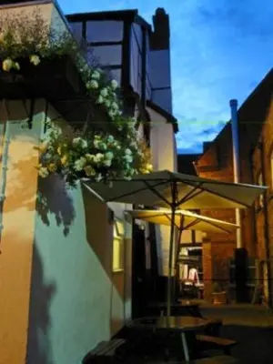 a table with an umbrella next to a building at Old Post Office in Shrewsbury