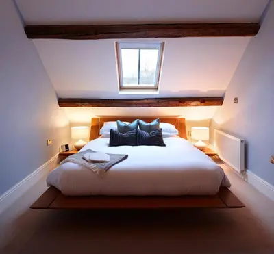 a bedroom with a large white bed with a window at Cross Foxes - Bar Grill Rooms in Dolgellau