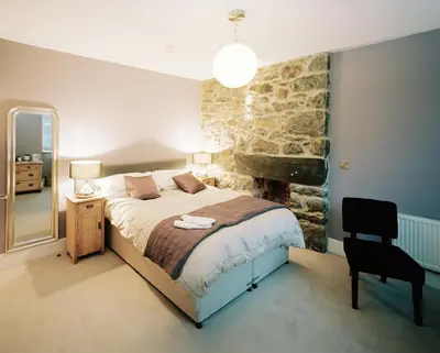a bedroom with a bed and a desk and a chair at Cross Foxes - Bar Grill Rooms in Dolgellau