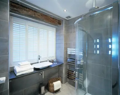 a bathroom with a sink and a glass shower at Cross Foxes - Bar Grill Rooms in Dolgellau