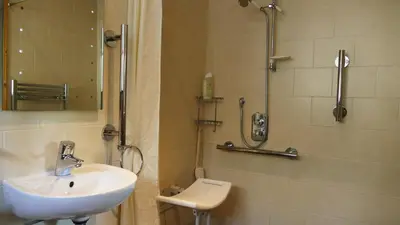 a bathroom with a sink and a shower at cosy ground floor disabled friendly room in farm house in Bala