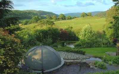 a dome in a garden with a view of a field at Bryn Melyn Farm Cottages in Bala