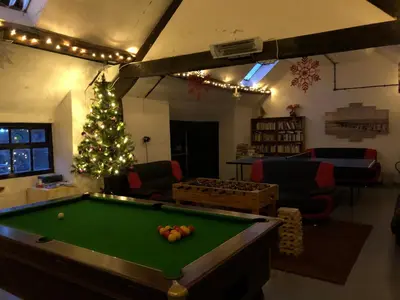 a living room with a pool table and a christmas tree at Bryn Melyn Farm Cottages in Bala