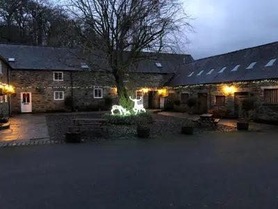 a building with a tree and lights in front of it at Bryn Melyn Farm Cottages in Bala