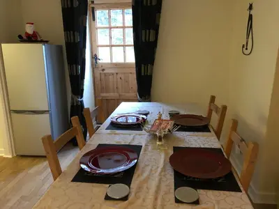 a kitchen with a table and a refrigerator at Bryn Melyn Farm Cottages in Bala