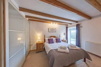 a bedroom with a bed with two towels on it at Beautiful 16th Century Ty Cerrig Cottage, set in stunning grounds with great views in Corwen