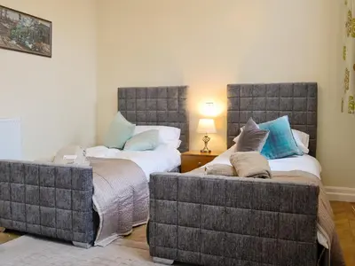 a bedroom with two beds and a couch at Yr Hen Fanc in Trawsfynydd