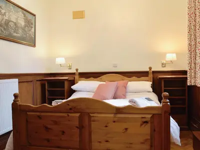 a bedroom with a wooden bed with white pillows at Yr Hen Fanc in Trawsfynydd