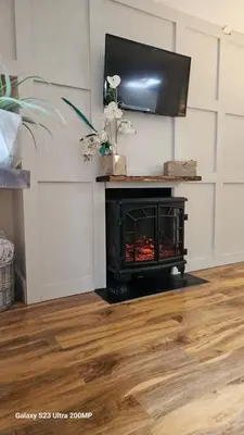 a living room with a fireplace with a television above it at Bala Holiday Suites in Bala