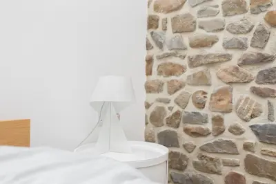 a white lamp on a table in front of a stone wall at Owl Barn at Penygaer Great views of Brecon Beacons in Llandovery