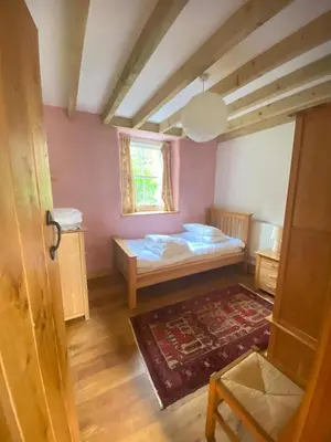 a small bedroom with a bed and a window at Yr Hen Feudy in Barmouth