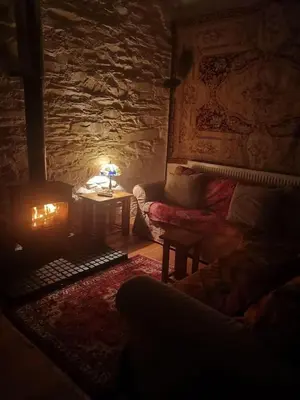 a living room with a couch and a table with a lamp at Yr Hen Feudy in Barmouth