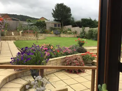 a view of a garden from a window with flowers at Carinya in Talgarth