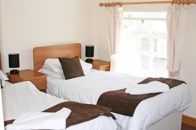 a bedroom with two beds and a window at The Gremlin Lodge in Brecon