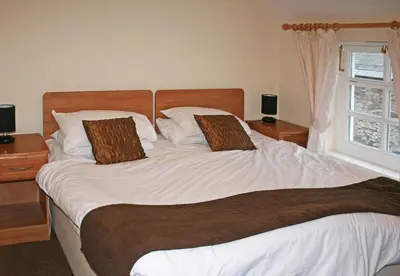 a bedroom with a large white bed with two pillows at The Gremlin Lodge in Brecon