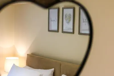 a mirror reflection of a bed with three pictures on the wall at Lake Cottages at Cwm Chwefru in Llanafan-fawr