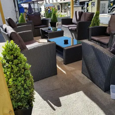 a group of wicker chairs and tables on a patio at The Lamb and Flag Inn in Rhayader