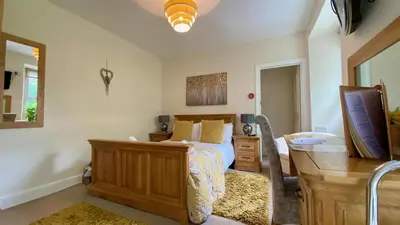 a bedroom with a bed and a desk and a television at Hafan Artro in Llanbedr