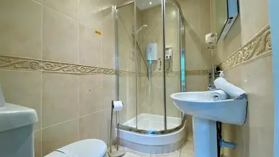 a bathroom with a shower and a toilet and a sink at Hafan Artro in Llanbedr
