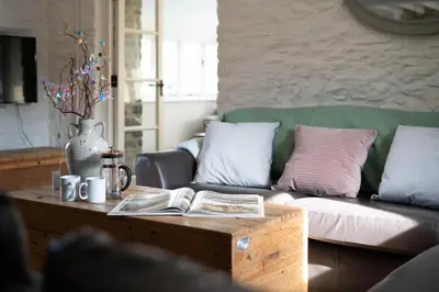 a living room with a couch and a coffee table at Granary Cottage with hot tub on organic farmland in Lampeter