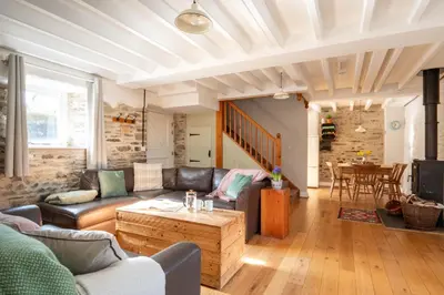 a living room with a couch and a table at Granary Cottage with hot tub on organic farmland in Lampeter