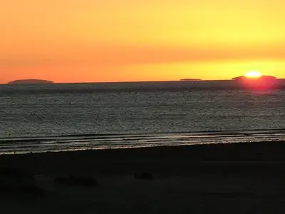 a sunset over the ocean with the sun setting at Sunray Suites in Barmouth