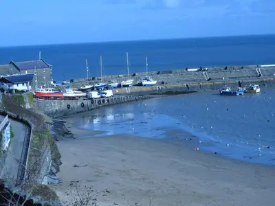 a beach with boats in the water and a harbor at Y Bwthyn in Tal-gareg