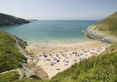 a group of people on a beach near the water at Y Bwthyn in Tal-gareg