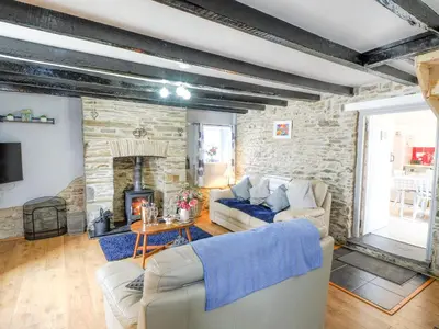 a living room with a couch and a fireplace at Y Bwthyn in Tal-gareg