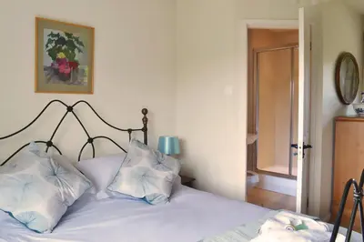 a bedroom with a bed with white sheets and pillows at The Oaks in Church Stretton