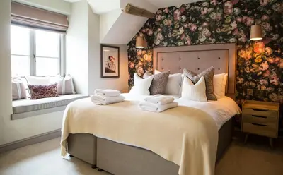 a bedroom with a large bed with towels on it at George III Hotel in Penmaenpool