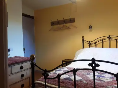 a bedroom with a bed and a wooden dresser at 6 Bridge St. in Brecon