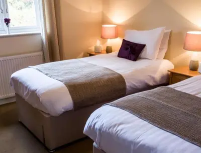 a hotel room with two beds and a window at The Roast Ox Inn in Builth Wells