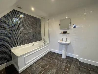 a bathroom with a sink and a tub and a toilet at The Castle Hotel in Llandovery
