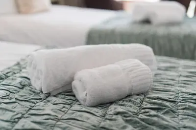 a stack of towels sitting on top of a bed at Marine Studios in Aberystwyth