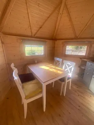 a room with a table and chairs in a cabin at Pandy B&B in Dorstone