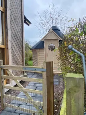 a bird house with a gate and a fence at Pandy B&B in Dorstone