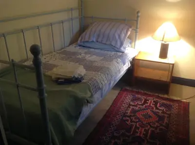 a bedroom with a bed and a lamp and a rug at Maescelyn in Aberystwyth