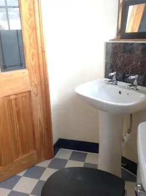 a bathroom with a white sink and a mirror at Maescelyn in Aberystwyth