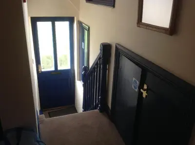 a hallway with a blue door and a stairway at Maescelyn in Aberystwyth
