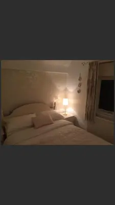 a bedroom with a bed with a lamp and a window at Ty Mawr Hotel in Llanbedr