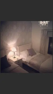 a bedroom with two beds and a table with a lamp at Ty Mawr Hotel in Llanbedr