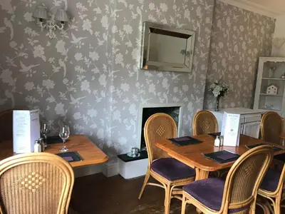 a dining room with two tables and chairs and a fireplace at Ty Mawr Hotel in Llanbedr