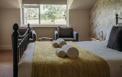 a bedroom with a bed with towels on it at Three Wells B&B in Llandrindod Wells