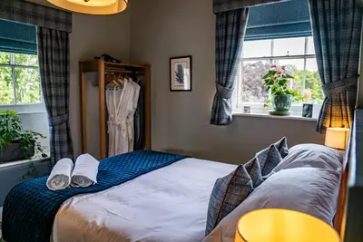 a bedroom with a bed with two slippers on it at Mytton and Mermaid - Brunning and Price in Shrewsbury