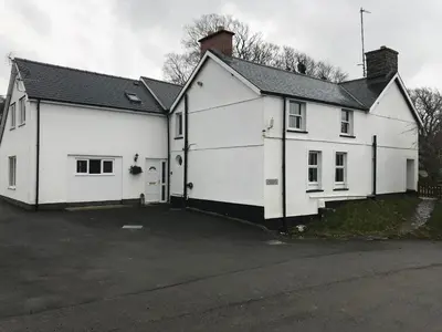 a white house with a parking lot in front of it at Aberystwyth, Pentre Farmhouse, in Capel Bangor