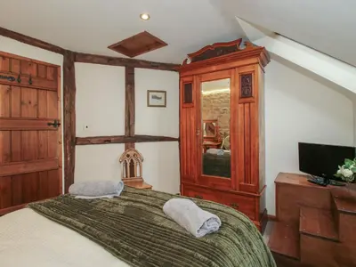 a bedroom with a large bed and a tv at Corn House in Plaish
